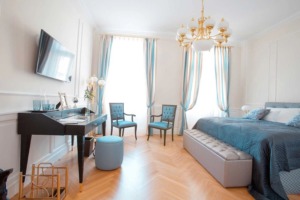 A guest room with a large bed and soft lighting